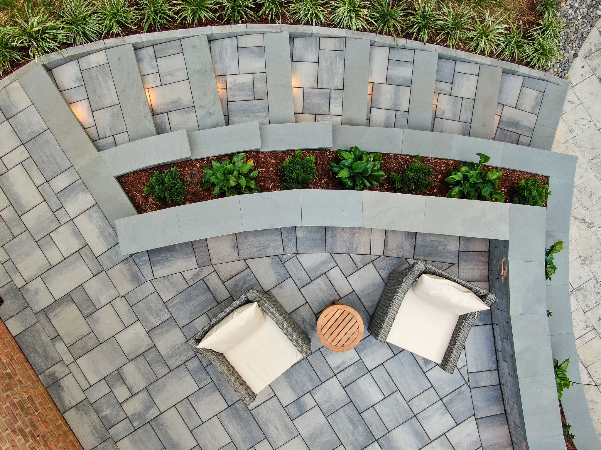 Aerial view of curved patio with seating area and planter wall